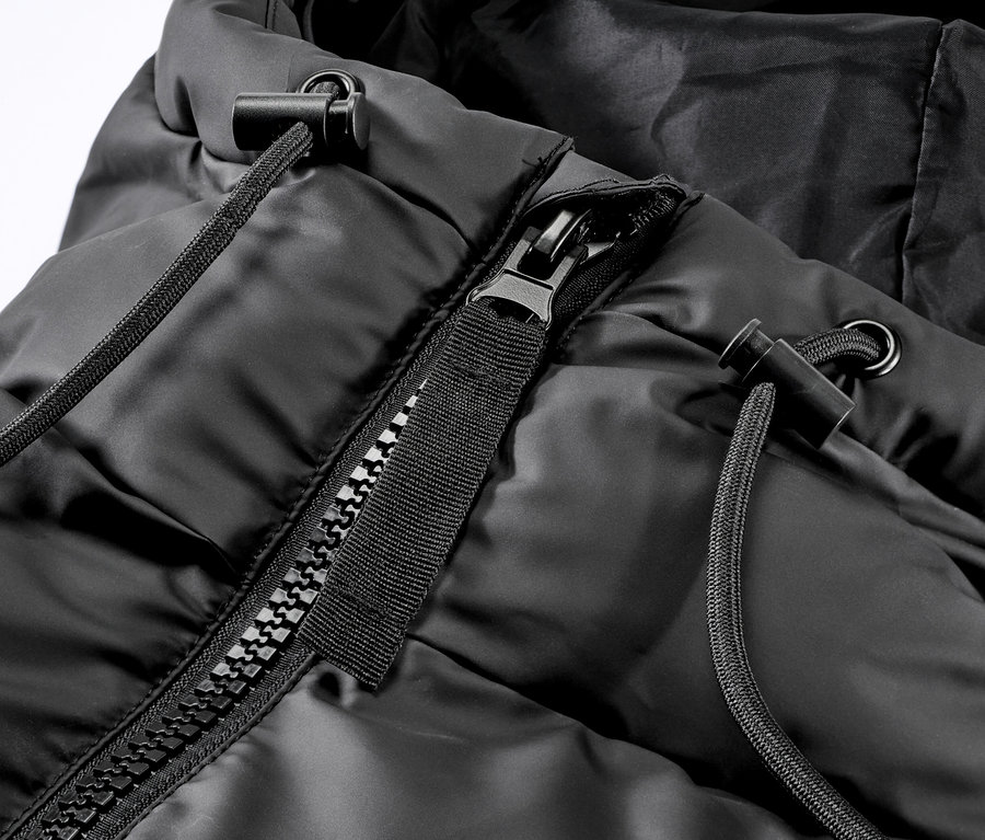 Zbliżenie na zimowy płaszcz przeciwdeszczowy z kapturem, zamkiem błyskawicznym i sznurkiem.