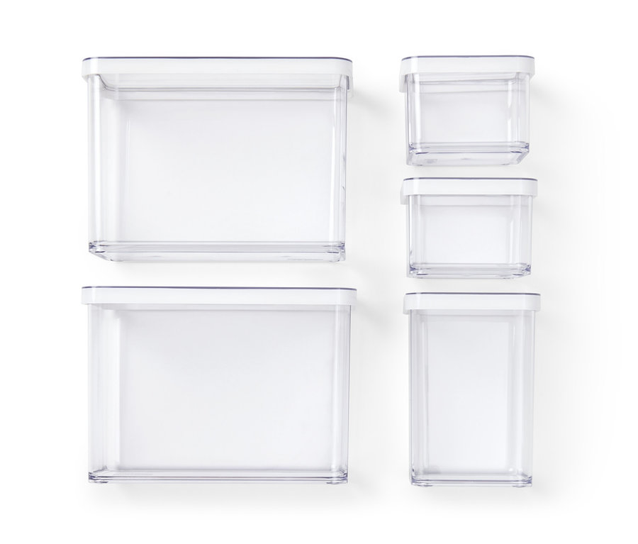 Pięć przezroczystych pojemników do przechowywania o różnych rozmiarach z białymi pokrywkami na białym tle.