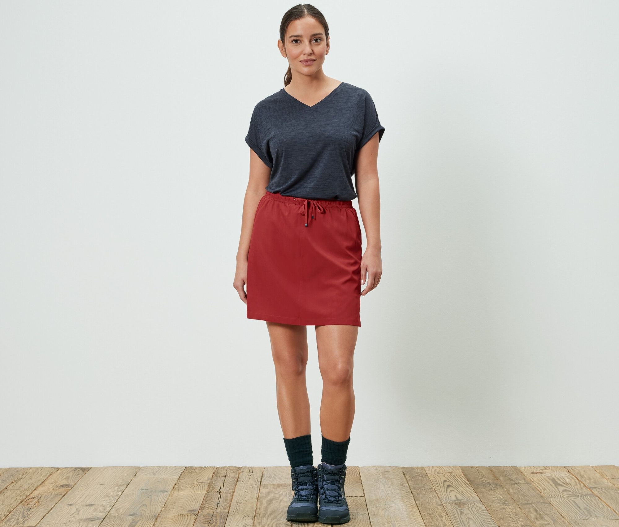 Kobieta pozuje w czerwonej spódnico-szortach funkcyjnych.