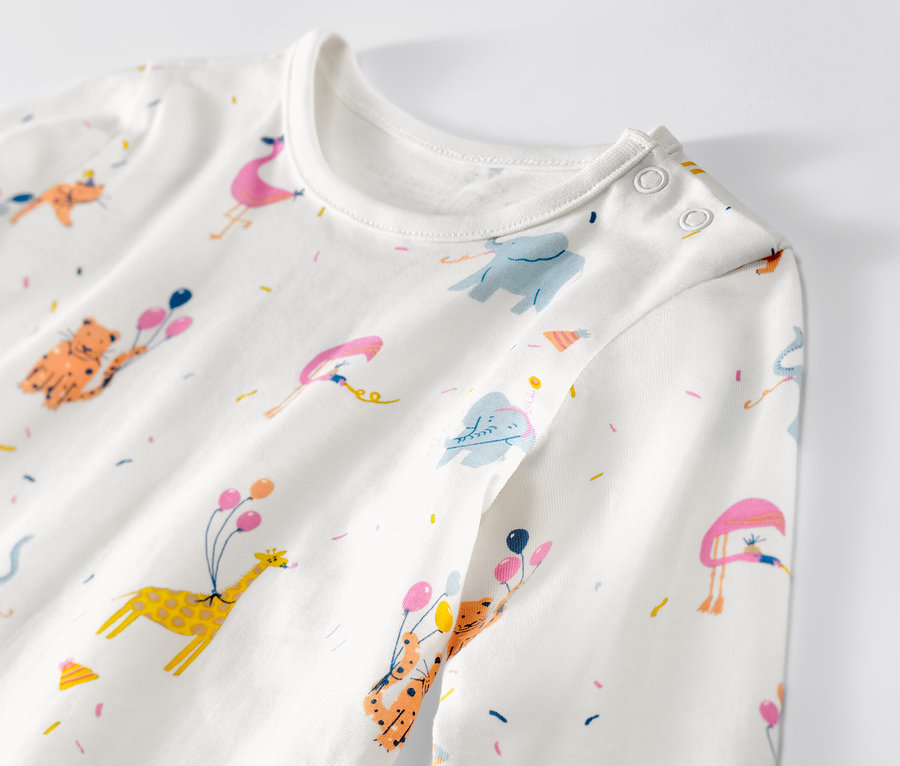 Zbliżenie na piżamę dziecięcą w zwierzęta z balonami i konfetti.