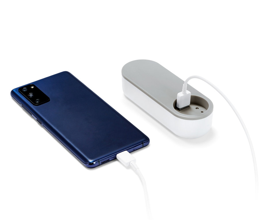 Granatowy smartfon ładuje się za pomocą powerbanku.