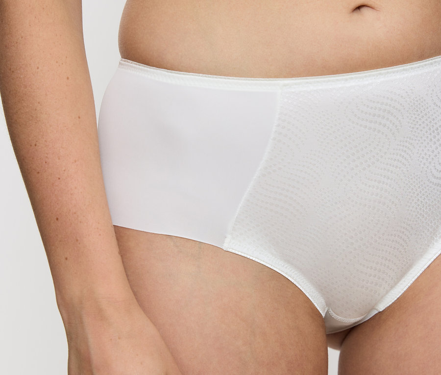 Tułów kobiety noszącej figi typu hipster Triumph Essential „Minimizer Hipster X”, Vanille.