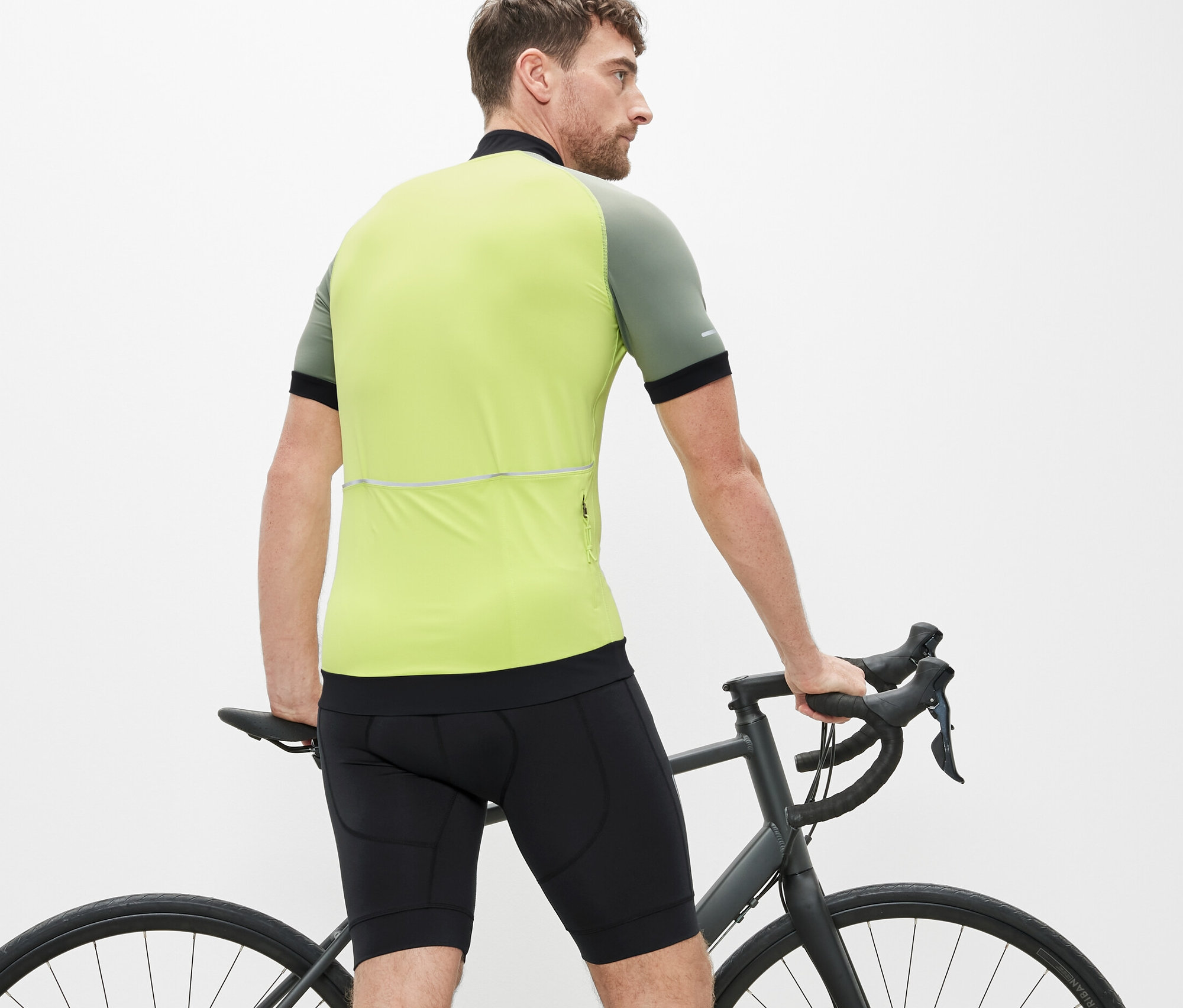 Mężczyzna stoi obok roweru i ma na sobie spodenki rowerowe.