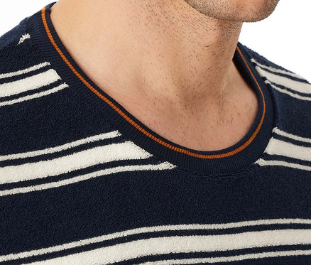 Zbliżenie mężczyzny w granatowym swetrze w paski z okrągłym dekoltem.