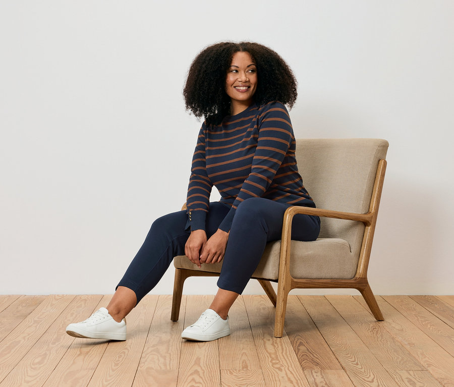 Kobieta siedzi w fotelu i ma na sobie joggpants.