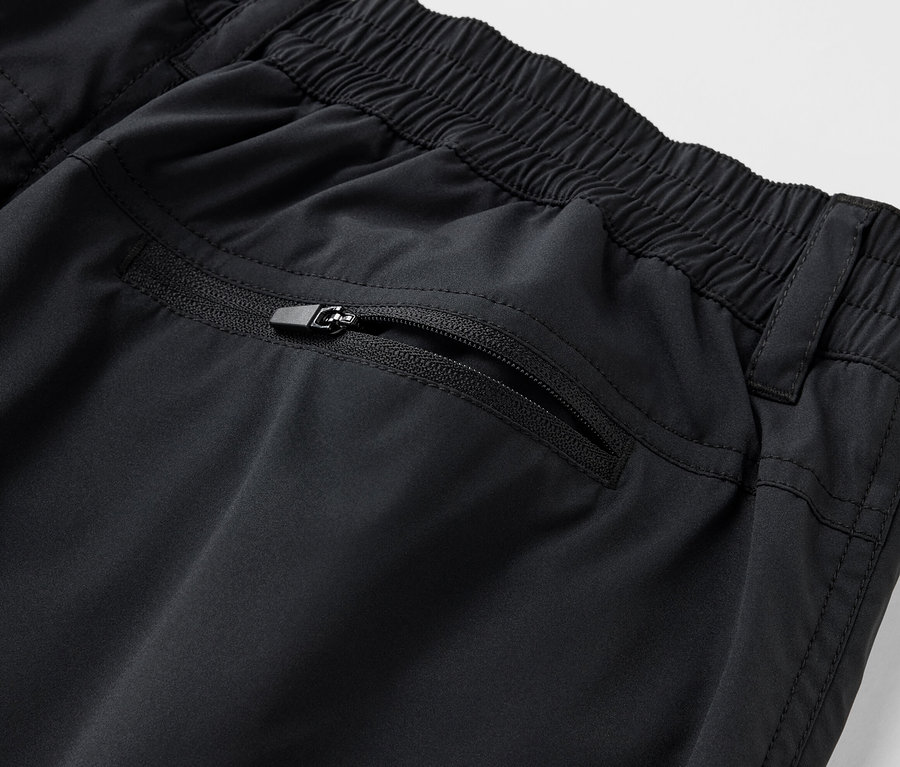 Zbliżenie na czarne szorty funkcyjne z softshellu z kieszenią na zamek.