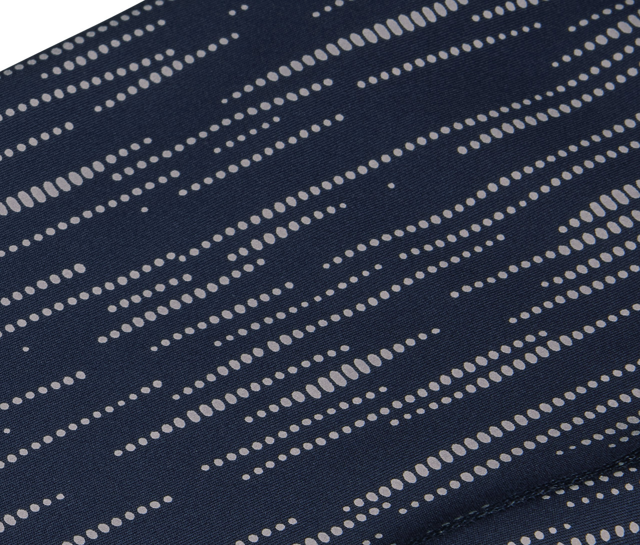 Zbliżenie granatowej tkaniny ze wzorem równoległych białych kropek.