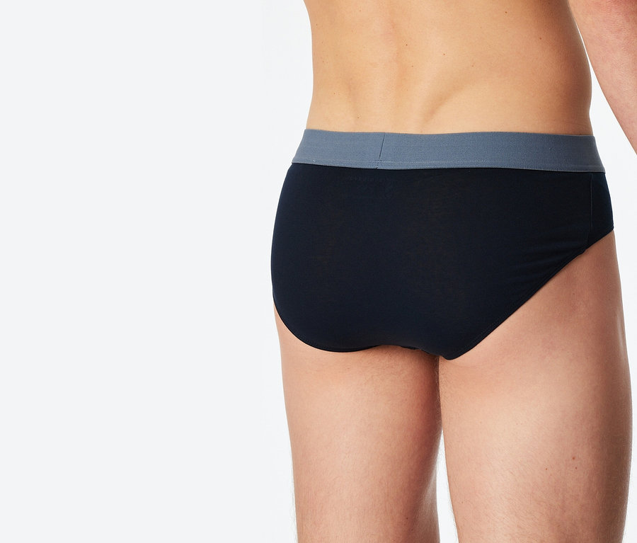 Zbliżenie na widok z tyłu osoby ubranej w czarne slipy z szarym pasem.