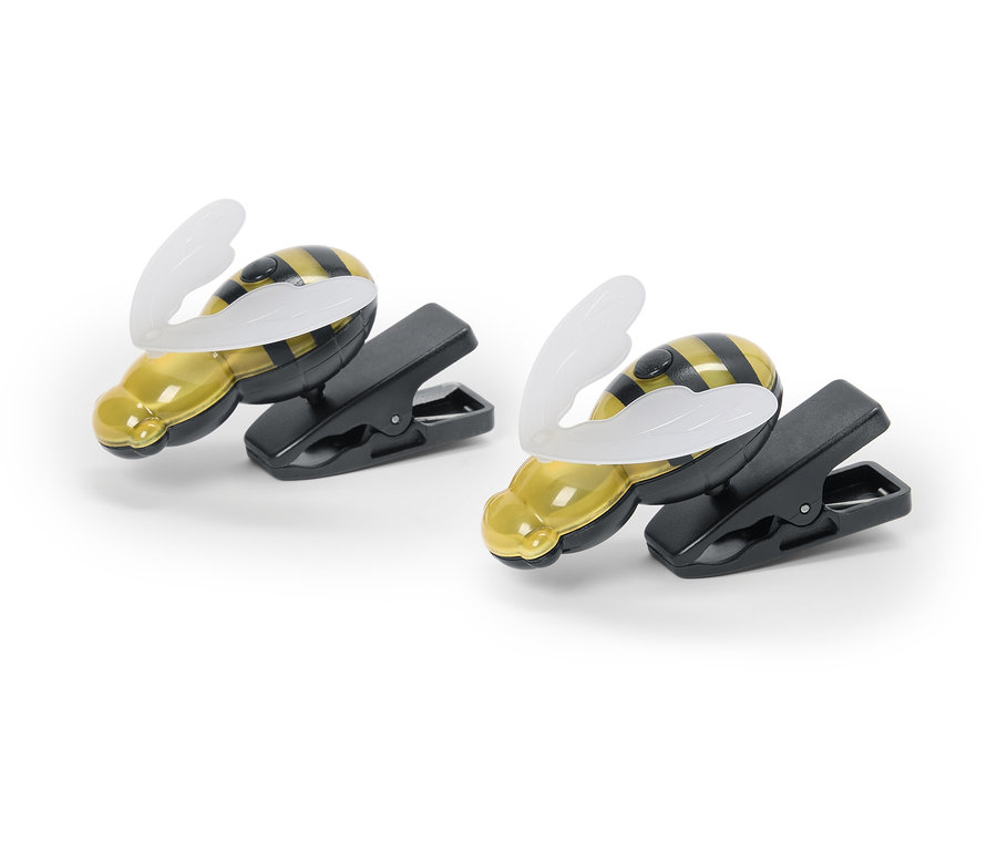 Dwie lampki-klipsy w kształcie pszczół leżą na białym tle.