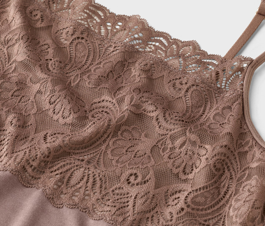 Zbliżenie beżowego topu koronkowego na ramiączkach spaghetti.