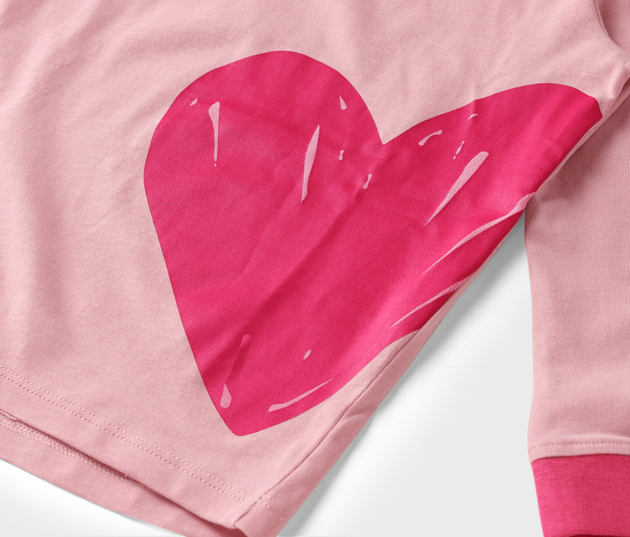 Zbliżenie różowej tkaniny z dużym, różowym nadrukiem serca.