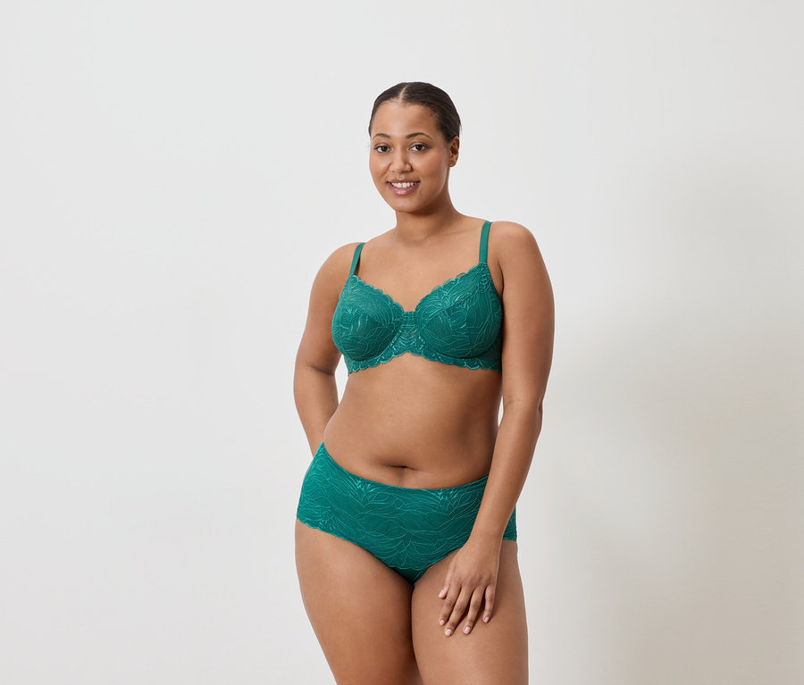 Kobieta ma na sobie szmaragdowozielony biustonosz i majtki z koronkowym wzorem.