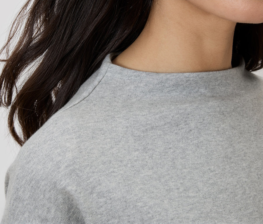 Zbliżenie kobiety w szarym topie z golfem.