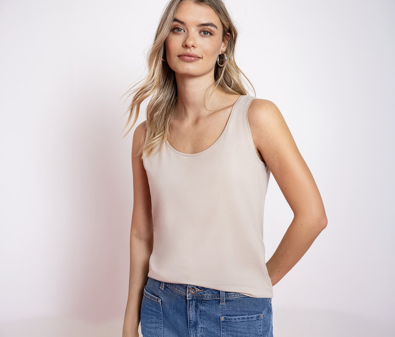 Kobieta z blond włosami ma na sobie top basic Street One i dżinsy.