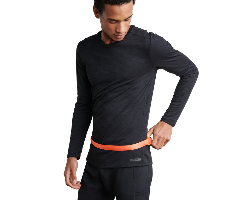 Mężczyzna zapina pasek LED wokół talii.