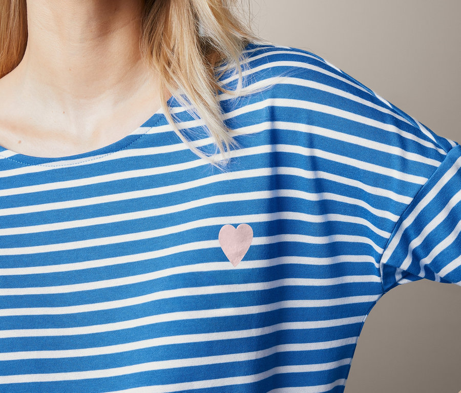 Blondynka ma na sobie bluzkę w paski.