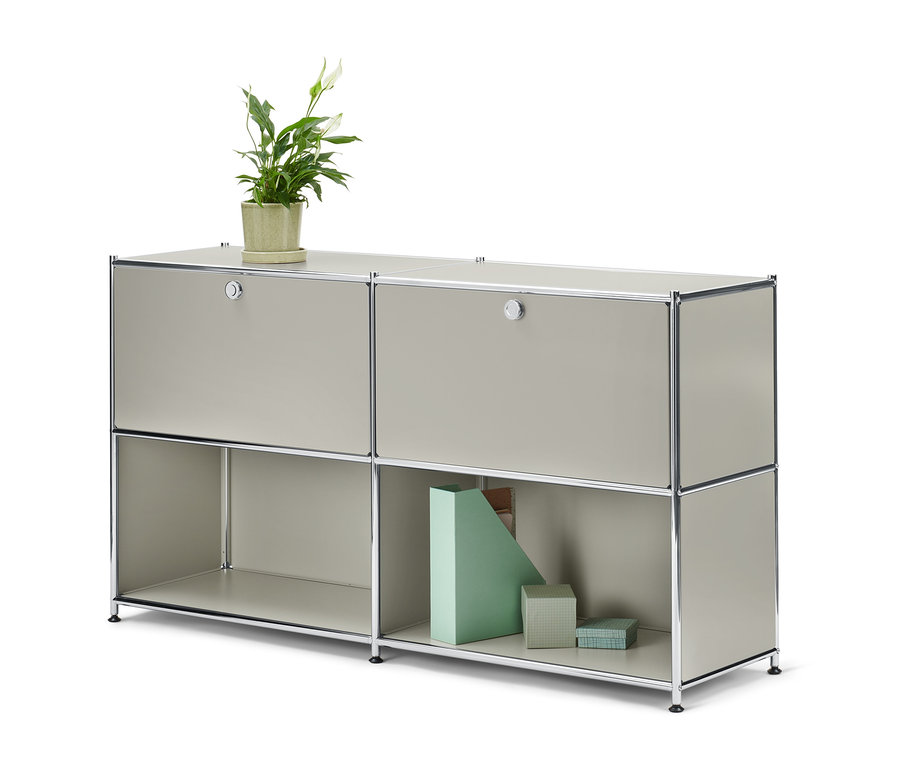 Jasnoszara szafka typu sideboard „CN3” z 2 parami drzwi do indywidualnego rozmieszczenia. Na górze szafki stoi doniczka z kwiatem.
