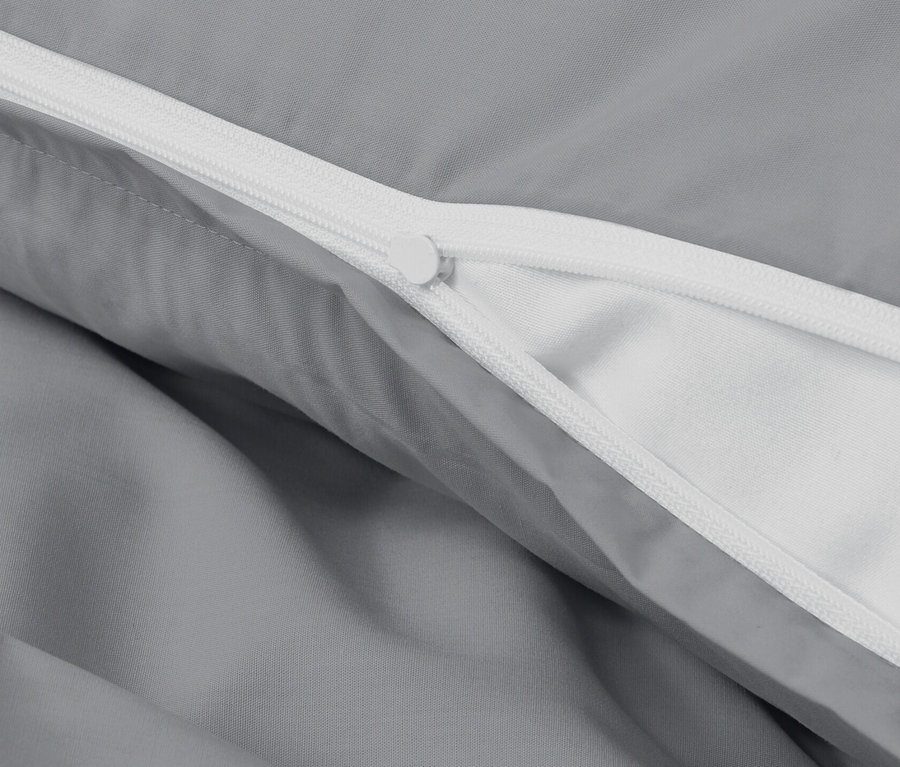 Zbliżenie na szarą pościel perkalową z zamkiem błyskawicznym.