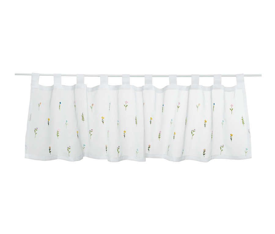 Krótka haftowana firanka z motywem kwiatowym wisząca na karniszu.