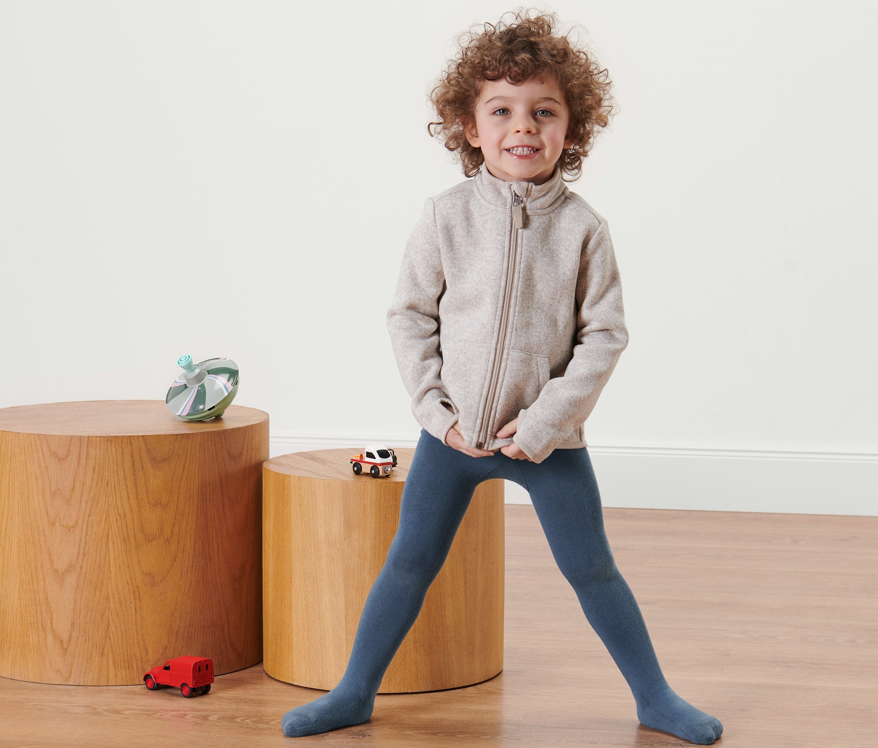 Dziecko stoi w niebieskich bawełnianych rajstopach.