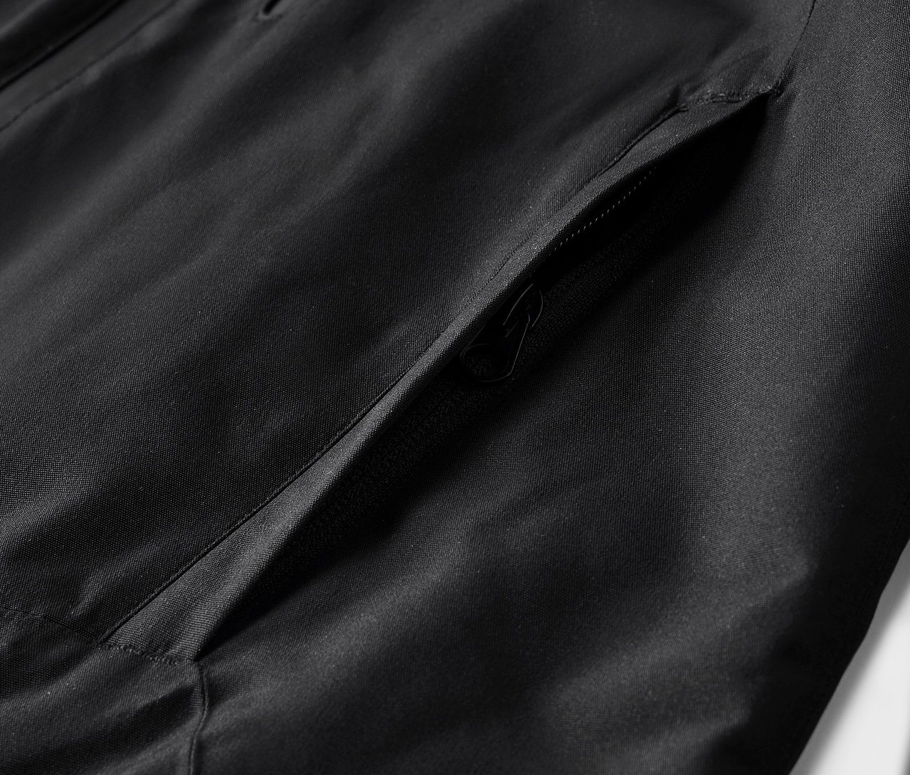 Szczegół czarnej kurtki z kieszenią.