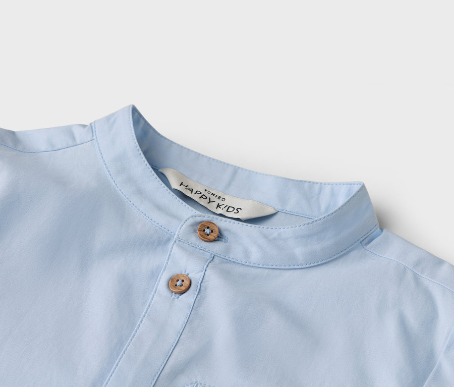 Zbliżenie na jasnoniebieską koszulę z dwoma guzikami i kołnierzykiem.
