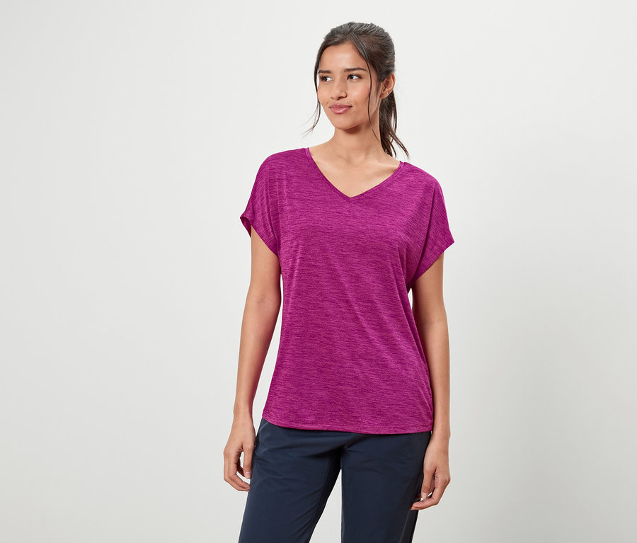 Kobieta ma na sobie fioletową koszulkę i niebieskie spodnie.