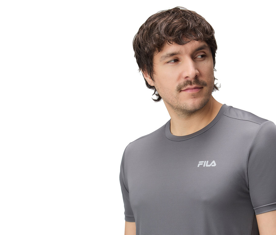 Mężczyzna ma na sobie szarą koszulkę Fila.