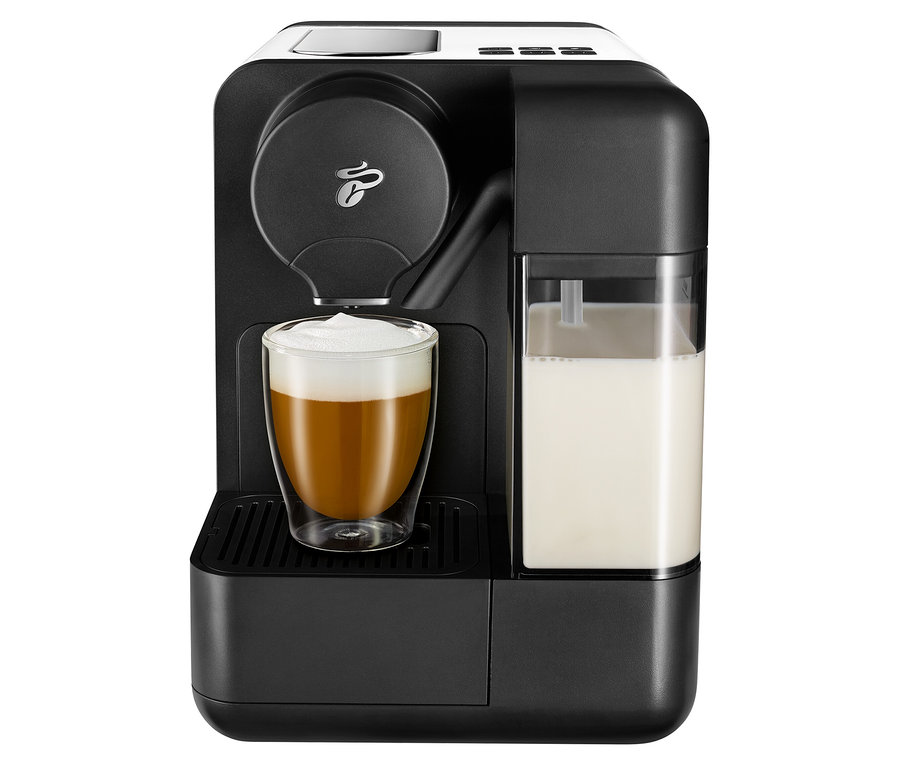 Czarny ekspres do kawy z białym mlekiem Cafissimo i szklanką wypełnioną kawą.