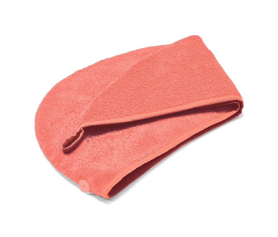 Koralowy ręcznik z turbanem na białym tle.