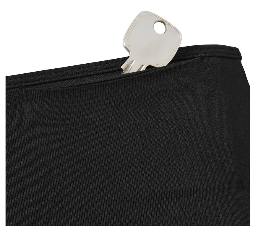 Srebrny klucz w kieszeni czarnych legginsów sportowych.