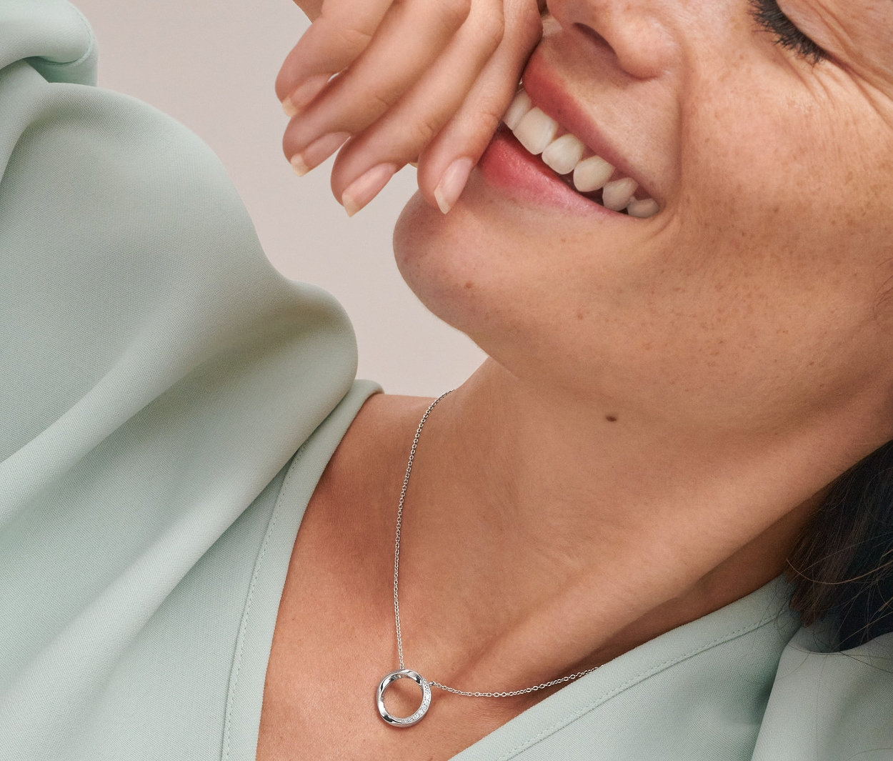 Uśmiechnięta kobieta w podwójnych kolczykach kreolach i naszyjniku Circle, srebro 925 rodowane, z cyrkoniami.