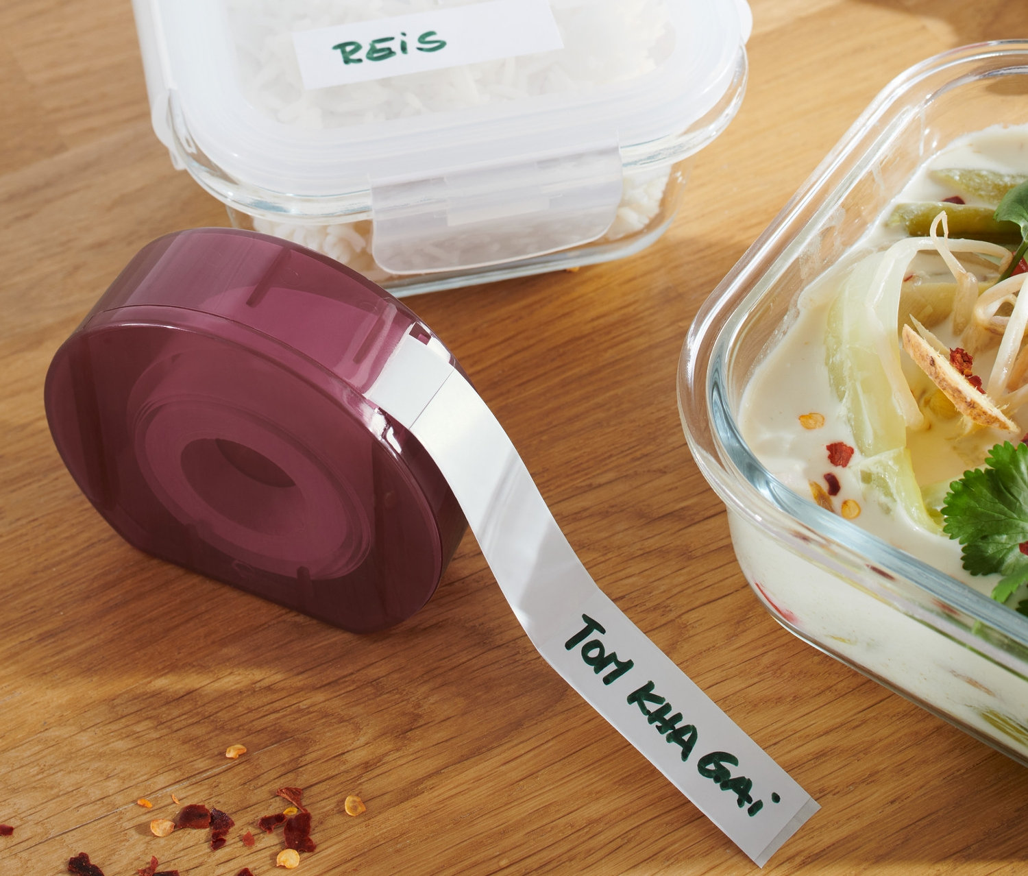 Urządzenie do etykietowania, pojemniki z ryżem i zupą na drewnianym stole.