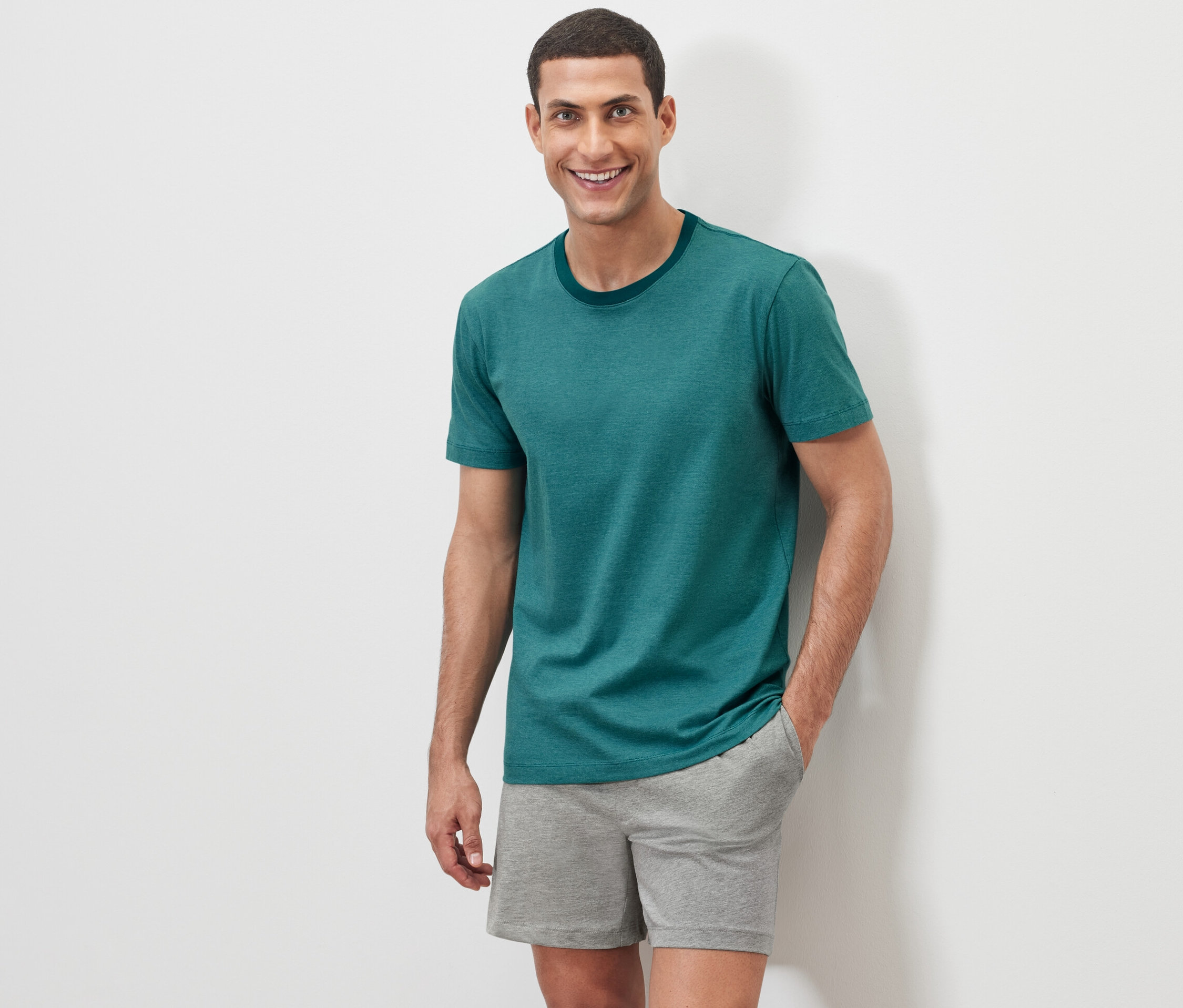 Mężczyzna pozuje na białym tle w piżamie.