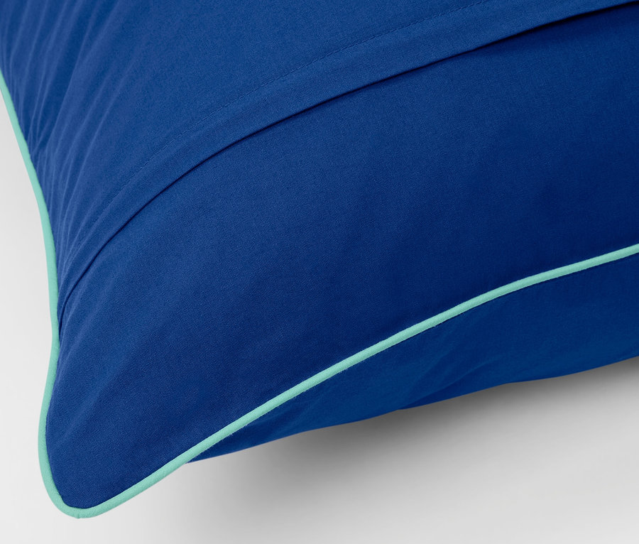 Szczegół niebieskiej pościeli z bawełny renforcé w standardowym rozmiarze z turkusowym brzegiem.