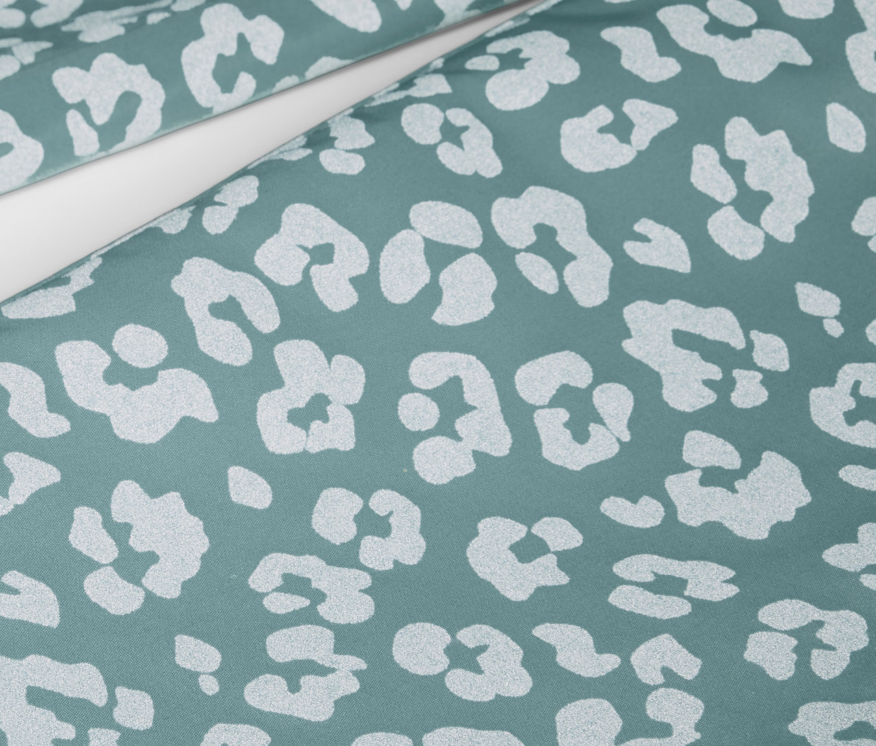 Zbliżenie na dziecięce spodnie przeciwdeszczowe z elementami odblaskowymi i zwierzęcym wzorem.