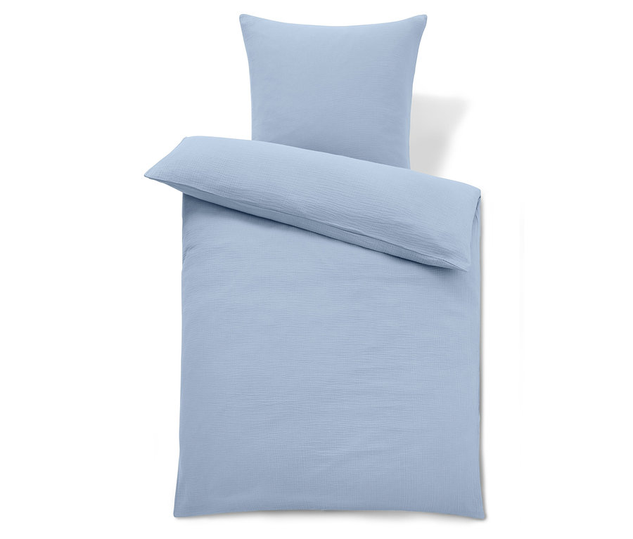 Jasnoniebieska pościel z poduszką na górze.