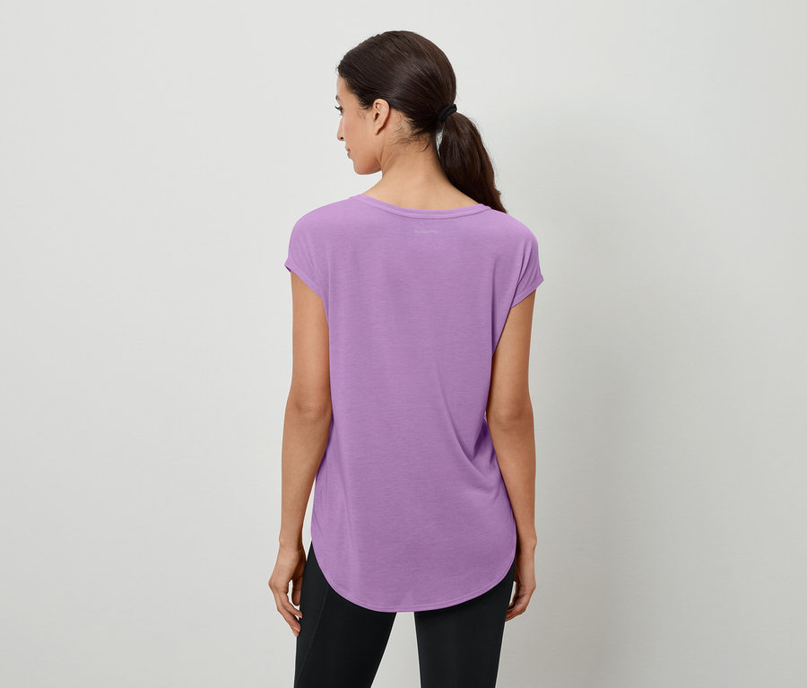 Z tyłu widać kobietę z kucykiem, ubraną w fioletową koszulkę i czarne legginsy.