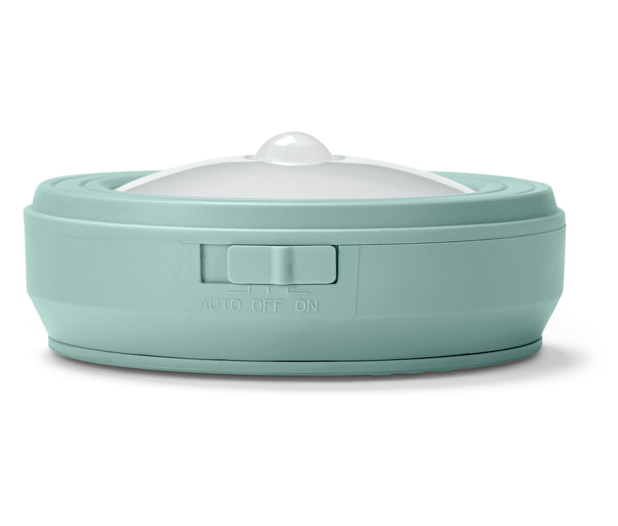 Szczegół okrągłej lampki nocnej w kolorze miętowej zieleni z białym dyfuzorem i przełącznikiem.