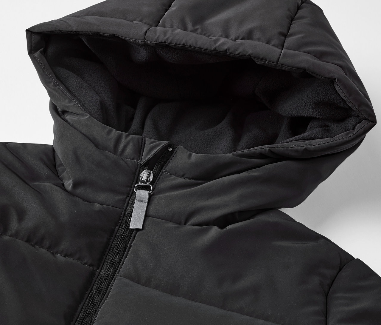 Zbliżenie na czarną kurtkę pikowaną z elementami odblaskowymi.