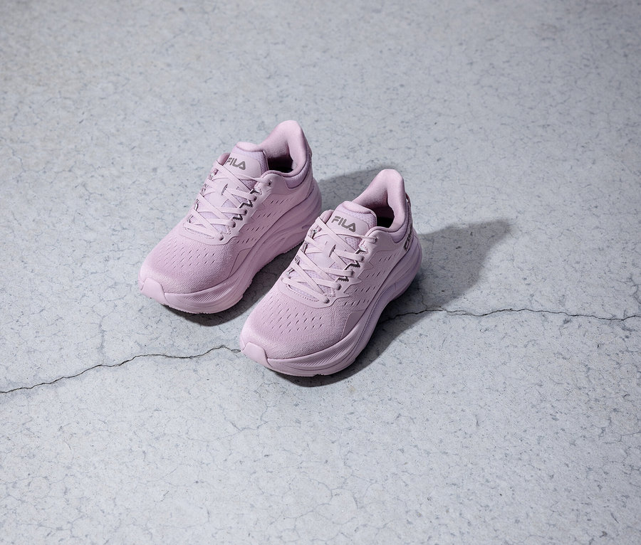 Dwa fioletowe buty do biegania Fila stoją na szarym tle.