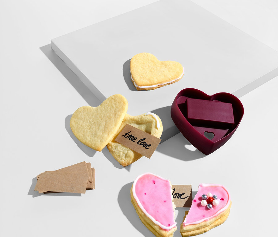 Ciasteczka w kształcie serca i foremka do ciasteczek
W kształcie serca leżą na białym tle.