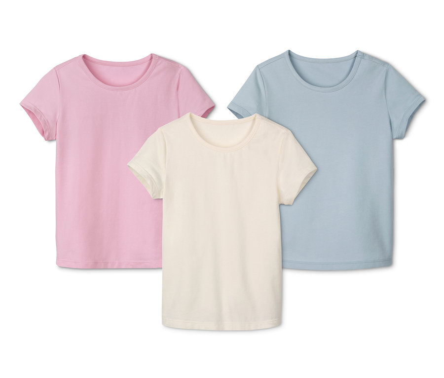 Trzy bawełniane koszulki: różowa, kremowa i błękitna.