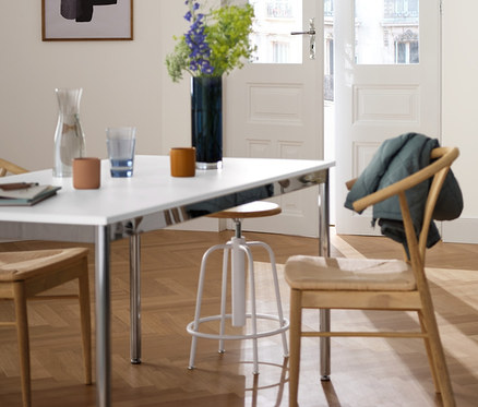 Wnętrze z regałem metalowym »CN3« z 2 szufladami, stołem metalowym »CN3«, ok. 140 x 80 cm i stołkiem barowym o regulowanej wysokości, białym.