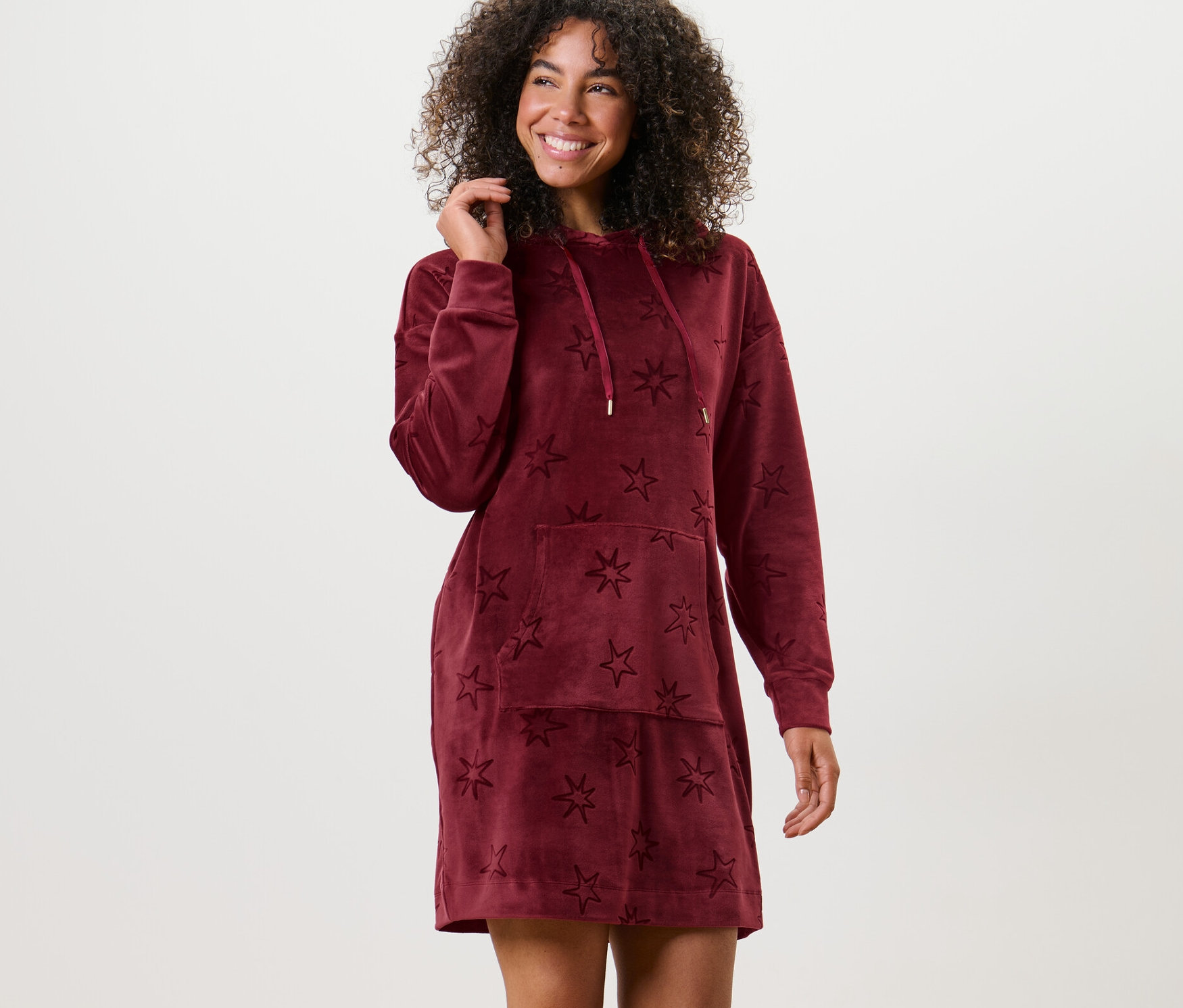 Kobieta pozuje w welurowej sukience rekreacyjnej w gwiazdy.