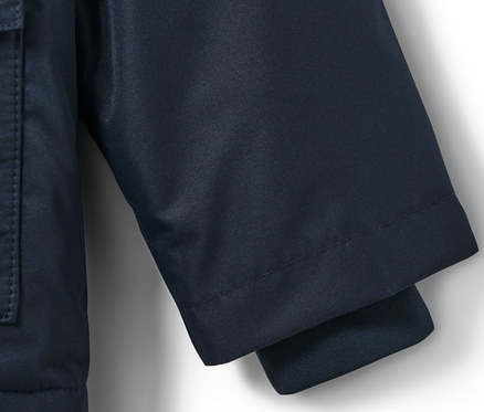 Szczegół dziecięcej kurtki termicznej przeciwdeszczowej z psem, pokazujący rękaw i kieszeń.