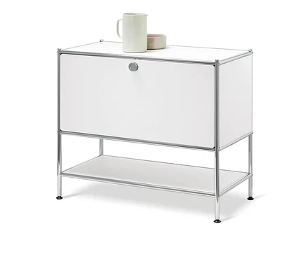 Biała szafka typu sideboard »CN3« z 1 klapą. Na górze stoi ceramiczny dzbanek i miska.