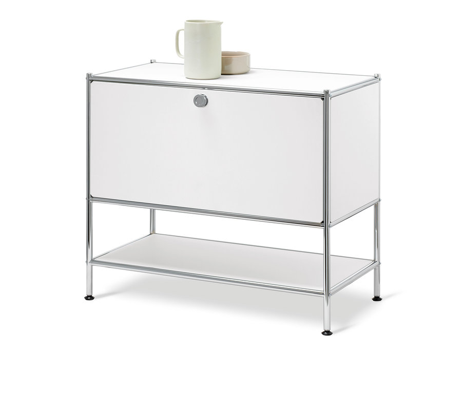 Biała szafka typu sideboard »CN3« z 1 klapą. Na górze stoi ceramiczny dzbanek i miska.