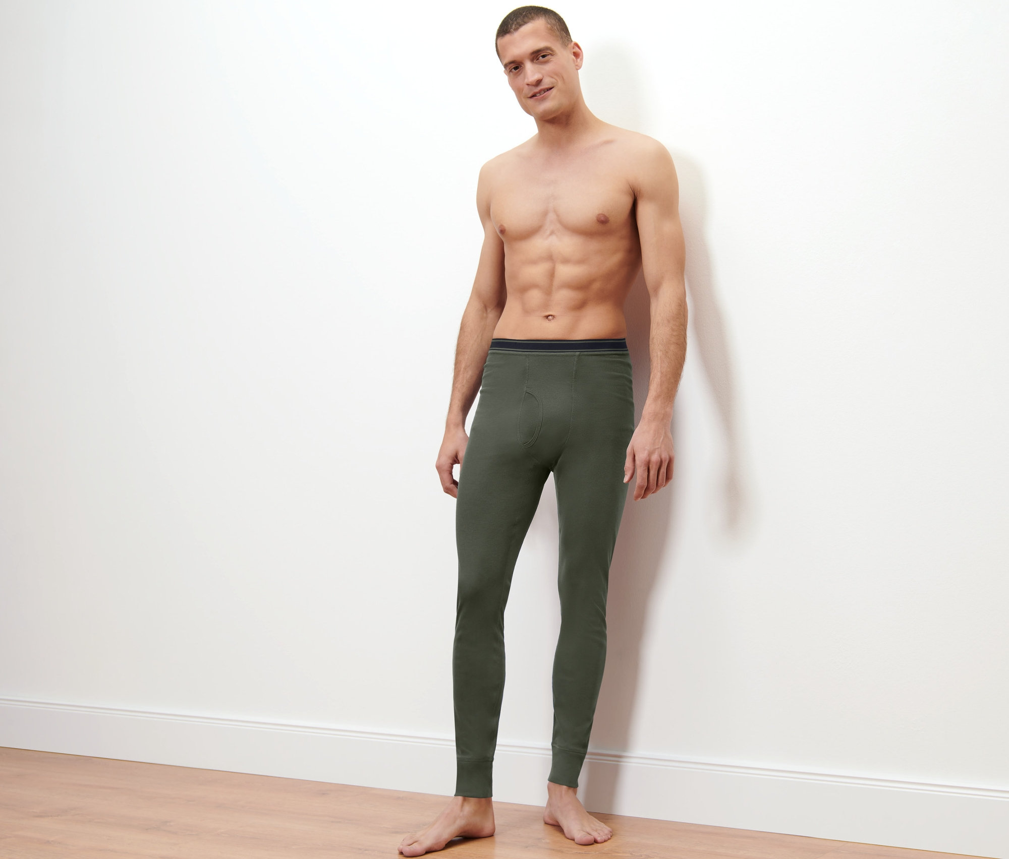 Mężczyzna pozuje na jasnym tle, ubrany w termoaktywne kalesony funkcyjne (2 pary).