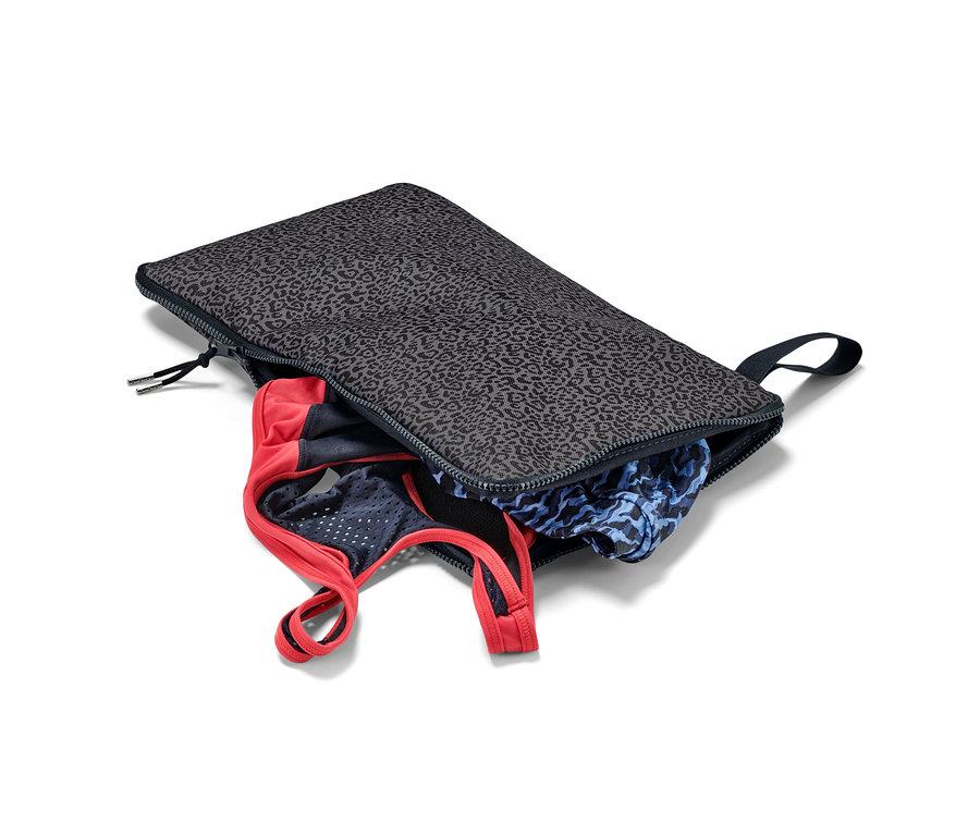 Otwarta podkładka do przebierania i worek na mokre rzeczy 2 w 1 z ubraniami w środku.